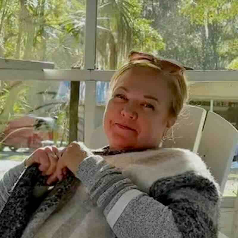 Dr. Kelly relaxing indoors by a window.