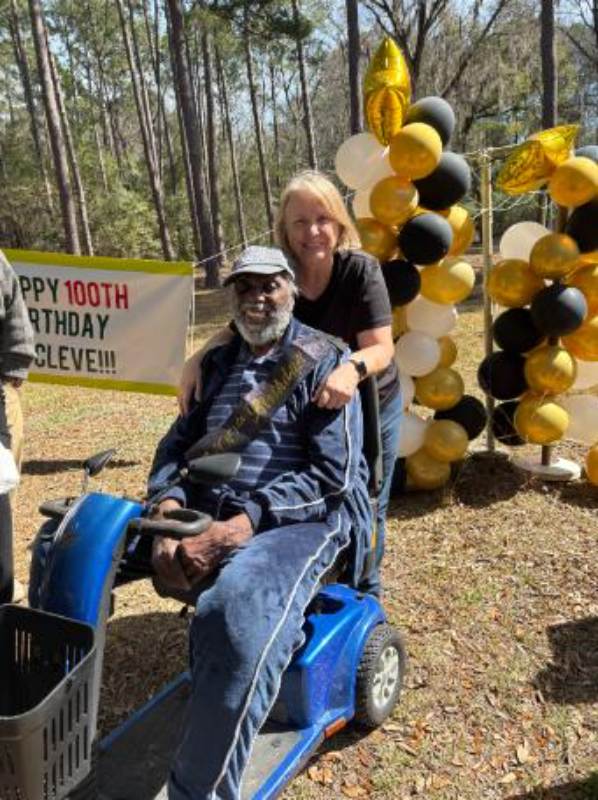 Celebrating 100th birthday outdoors with decorations.