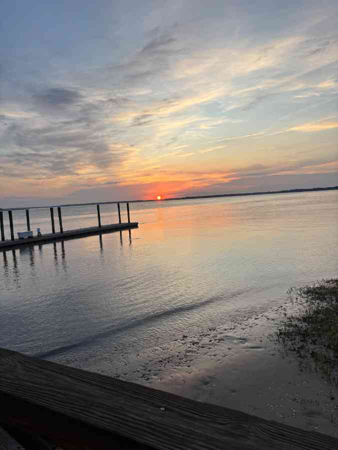 Serene sunset over calm lake with docks.